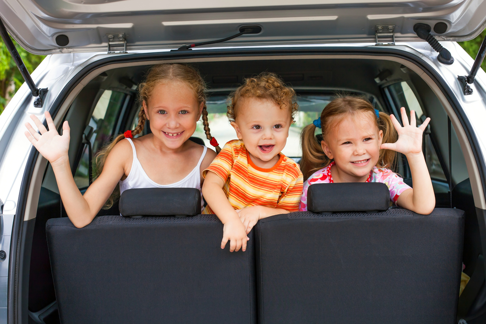 3 happy kids in car